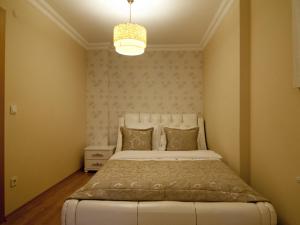 a bedroom with a large white bed with a chandelier at Aymira Suite Hotel in Istanbul