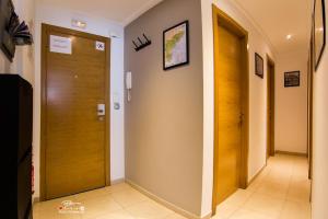 a hallway with a wooden door and a tile floor at Apartament Solar in Alicante