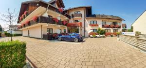 a blue car parked in front of a building at Kurhotel Anders in Bad Füssing