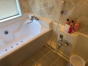 a bathroom with a bath tub and a sink at Hotel Vegas (Adult Only) in Sapporo