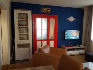een woonkamer met een rode deur en een televisie bij Ferienhaus Wohnen unter Freunden in Arnstadt