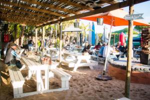 a group of people sitting at tables in a restaurant at Pili Pili Beach Cabanas in Sedgefield