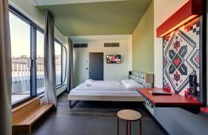une chambre avec un lit et une grande fenêtre dans l'établissement MEININGER Budapest Great Market Hall, à Budapest