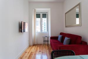 uma sala de estar com um sofá vermelho e uma janela em CARDAL em Lisboa