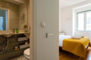 uma casa de banho com uma cama, um lavatório e um WC. em CARDAL em Lisboa