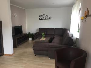 a living room with a brown couch and a tv at Ferienhaus Burggraf in Zermüllen