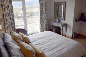 1 dormitorio con cama y ventana grande en Dunarain Bed & Breakfast en Tarbert