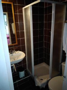 La salle de bains est pourvue d'une douche et d'un lavabo. dans l'établissement Edith Cavell10 Lisbon Guest House, à Lisbonne
