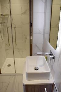 bagno bianco con lavandino e doccia di Dunarain Bed & Breakfast a Tarbert