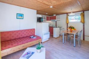 a living room with a couch and a table at Bungalows & Rooms - Gît'Ôstal in Carcassonne