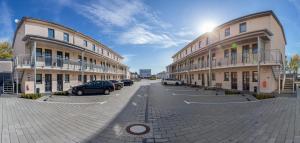 a parking lot with cars parked between two buildings at TRIO Apartment Hotel Berlin in Berlin