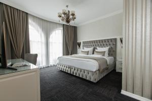 クラスノダールにあるBoutique-hotel Stolicaのベッドルーム1室(大型ベッド1台、シャンデリア付)