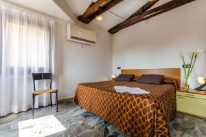 a bedroom with a bed and a chair and a window at Hotel Ariel Silva in Venice