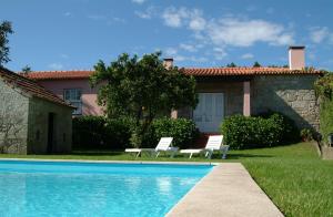 a house with a swimming pool and two chairs at Quinta do Vale do Monte in Viana do Castelo