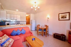 sala de estar con sofá rojo y mesa en Almadrava Playa Apartamento, en Denia