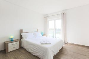a bedroom with a white bed and a window at Vitamin Sea, The Sea View Apartment in Baleal +34 photos