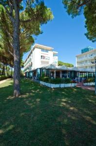 einen Park mit einem Baum und einem Gebäude in der Unterkunft Hotel King in Lido di Jesolo