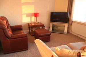 a living room with furniture and a flat screen tv at headland apartments in Hartlepool