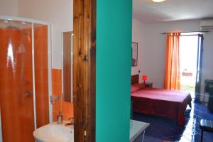 a bathroom with a bedroom with a bed and a tub at Bed& Breakfast Maredomus in Milazzo