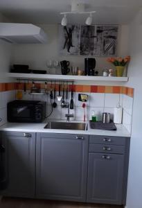 a kitchen with a sink and a microwave at Stenaberg in Kungsbacka