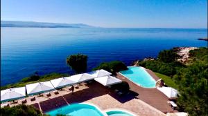 an aerial view of a swimming pool and the ocean at Hotel Punta Negra in Alghero