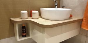 a bathroom counter with a sink and a bottle of alcohol at Apartmani Zora in Trogir