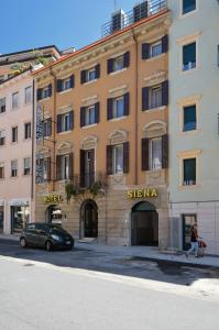 a building with a woman walking in front of it at Hotel Siena in Verona