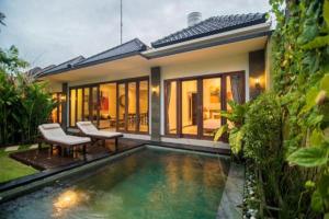 a house with a swimming pool in front of it at Villa Raka in Legian