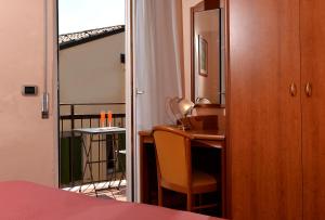 um quarto com uma secretária, uma cadeira e um espelho em Hotel Siena em Verona