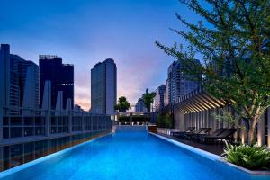 a swimming pool on top of a building with a city skyline at Somerset Maison Asoke in Bangkok