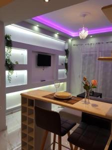 a kitchen with a table with chairs and a purple ceiling at kristina family home in Nea Iraklia