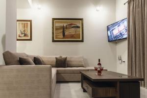 uma sala de estar com um sofá e uma televisão de ecrã plano em Villa Irina em Míloi