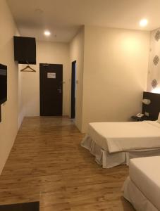 um quarto de hotel com duas camas e uma televisão em Casa Bonita Hotel em Malaca