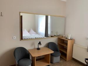 lustro w pokoju z 2 krzesłami i biurkiem w obiekcie Willa Solna w Kołobrzegu