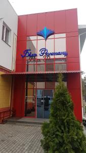 un bâtiment rouge avec un panneau bleu dans l'établissement готель Біля фонтану, à Vinnytsia
