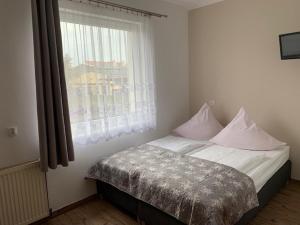 a bed in a room with a window and a bed sidx sidx sidx at Willa Solna in Kołobrzeg +5 photos