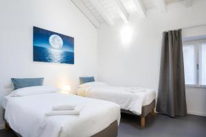 two beds in a room with a moon picture on the wall at CASA PERLASCA in Cernobbio