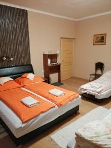 バコニュベルにあるBakonybéli Patakpart Vendégházのベッドルーム1室(大型ベッド1台、オレンジのシーツ付)