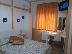 a bedroom with a bed and a desk and a window at B&B RELAX in Messina