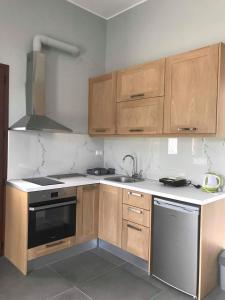 a kitchen with wooden cabinets and a sink and a stove at Light blue house 3 Apartments in Poulithra +16 photos