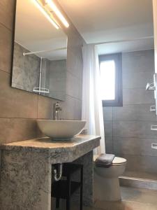 a bathroom with a sink and a toilet at Light blue house 3 Apartments in Poulithra