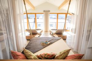 a living room with a table and swing chairs at HELDs Vitalhotel in Ruhpolding