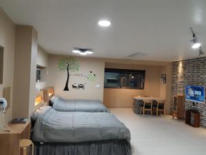 een slaapkamer met een bed en een boom aan de muur bij La Masion Benie in Seogwipo