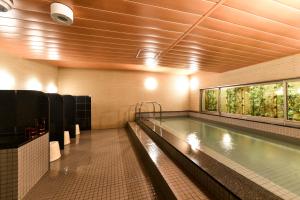 a swimming pool in a bathroom with a large window at Hida Takayama Washington Hotel Plaza in Takayama