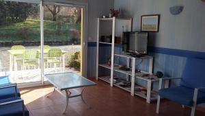 a living room with a tv and a chair and a table at LA MARVINIERE in Saint-Bonnet-sur-Gironde