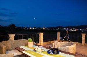 een tafel en stoelen op een balkon in de nacht bij Acacia House Apartments in Ambelókipoi
