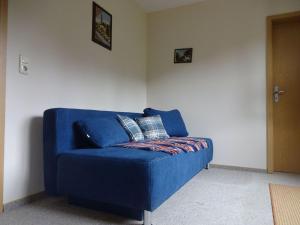 a blue couch with two pillows on it in a room at Ferienwohnung Pöhlmann in Bad Lobenstein