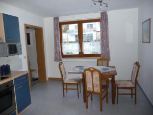 a kitchen with a table and chairs and a window at Ferienwohnung Pöhlmann in Bad Lobenstein