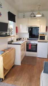 a kitchen with white cabinets and a stove top oven at For-Get-Me-Not Chalet semi detached in Bridlington