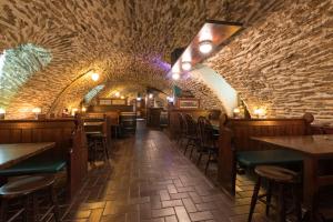ein Restaurant mit Steinmauer, Tischen und Stühlen in der Unterkunft Hotel Residenz23 in Weilburg